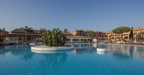 a swimming pool with a plant in the middle of it at Ilunion Sancti Petri in Chiclana de la Frontera