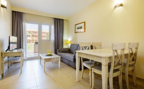 a living room with a table and a couch at Ilunion Sancti Petri in Chiclana de la Frontera