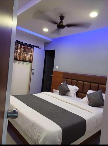 - une chambre avec un lit et un ventilateur de plafond dans l'établissement Hotel Anjali palace, à Ahmedabad