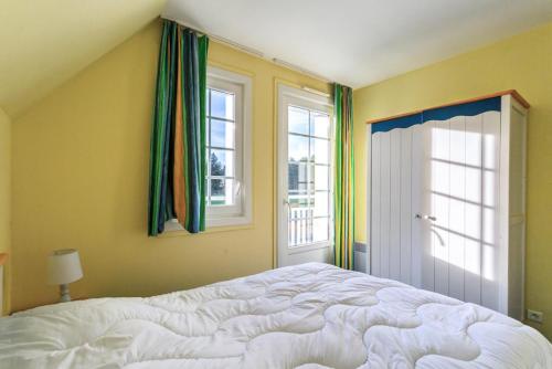 une chambre avec un grand lit et deux fenêtres dans l'établissement Les Maisons de Belle Dune - maeva Home - Maison 3 Pièces 6 Personnes Confort MAE-2274, à Fort-Mahon-Plage