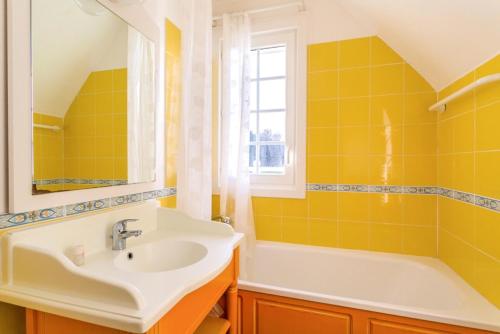 La salle de bains jaune est pourvue d'un lavabo et d'une baignoire. dans l'établissement Les Maisons de Belle Dune - maeva Home - Maison 3 Pièces 6 Personnes Confort MAE-2274, à Fort-Mahon-Plage