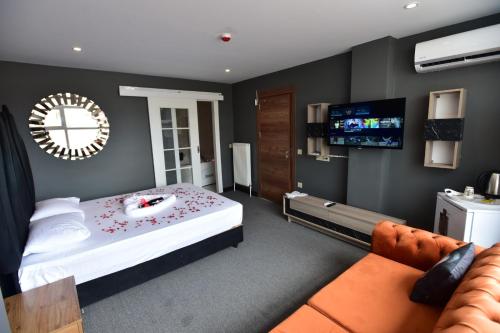 Lara Apartments في إسطنبول: غرفة نوم بسرير وتلفزيون وأريكة