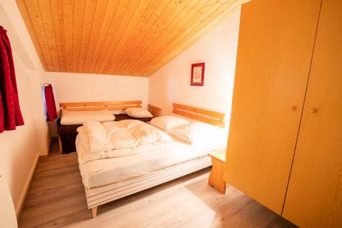 1 dormitorio con 2 camas y techo de madera en Résidence La Chapelle - 3 Pièces pour 10 Personnes 197448, en Villarodin-Bourget