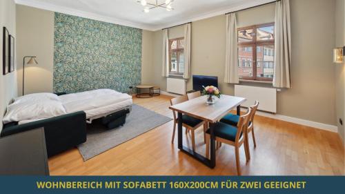 バンベルクにあるSandAPART34 - 4 tolle FeWos von 1-9 Pers mitten in der Altstadtのベッドルーム1室(ベッド1台、テーブル、椅子付)