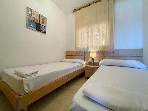 two twin beds in a room with a window at Apartamentos Costamar 3000 in Torre de la Sal