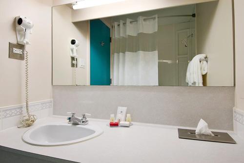 a bathroom with a sink and a large mirror at The Burntwood Hotel in Thompson
