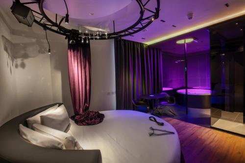um quarto com uma cama branca e iluminação roxa em SuiteSistina for Brave Lovers em Roma