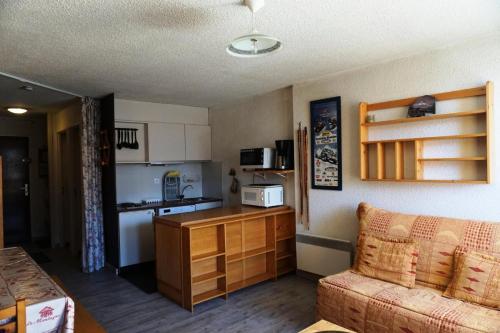 un salon avec un canapé et une cuisine dans l'établissement Résidence Rond Point I - studio 4/5 personnes MAE-1549, à Orcières