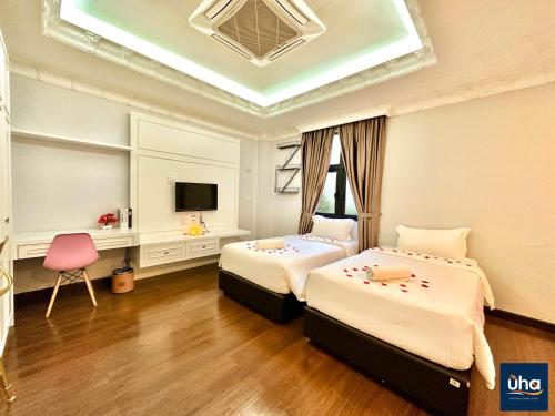 a bedroom with two beds and a tv in it at Well Hotel By Maco at Legoland in Gelang Patah