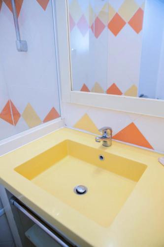 d'un lavabo jaune dans la salle de bains pourvue d'une fenêtre. dans l'établissement Résidence Promenade des Bains - maeva Home - Studio 4 Personnes Confort MAE-2296, à Saint-Raphaël
