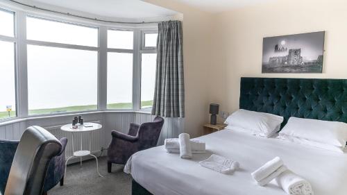 una camera d'albergo con letto, tavolo e sedie di The Wheeldale a Whitby