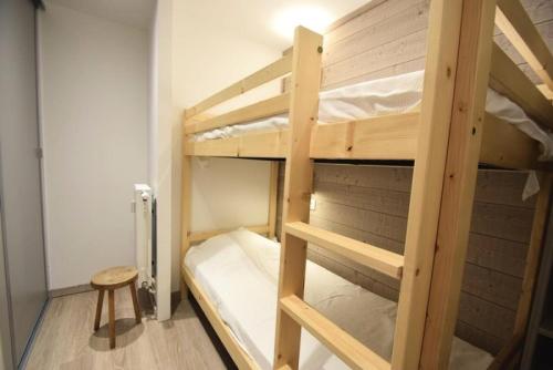 a room with two bunk beds and a stool at Résidence Le Makalu - 4 Pièces pour 9 Personnes 964 in Aime-La Plagne