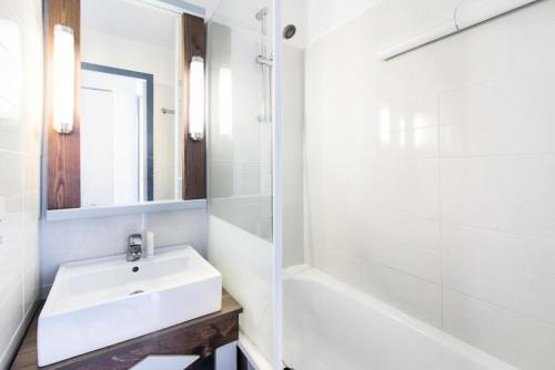 une salle de bain avec un lavabo, une baignoire et un miroir dans l'établissement Résidence Port Bourgenay - maeva Home - Studio 5 Personnes Sélection MAE-2312, à Talmont-Saint-Hilaire