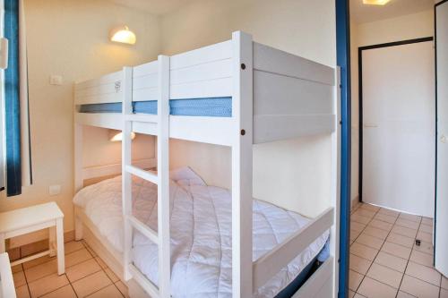 Ce lit superposé se trouve dans une petite chambre dotée de lits superposés. dans l'établissement Résidence Port Bourgenay - maeva Home - Studio 5 Personnes Sélection MAE-2315, à Talmont-Saint-Hilaire