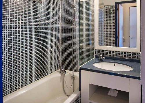 une salle de bain avec un lavabo, une baignoire et un miroir dans l'établissement Résidence Port Bourgenay - maeva Home - Studio 5 Personnes Sélection MAE-2315, à Talmont-Saint-Hilaire