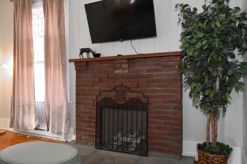 a brick fireplace with a television on top of it at Walk To Parks, Dining & Lake! Game Room! Hot Tub! in Watkins Glen