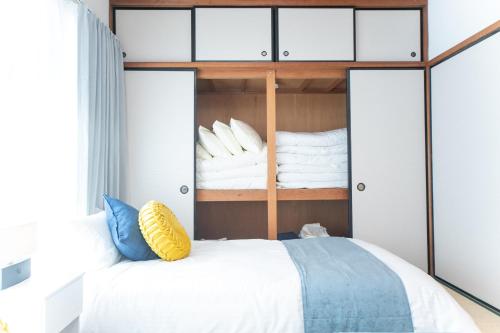 a bedroom with a bunk bed with white sheets and pillows at Suzuka Smile Room in Suizawa