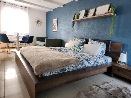 um quarto com uma cama com uma parede azul em Maison 5 chambres proche Basel Germany em Saint-Louis
