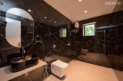 a black bathroom with a toilet and a mirror at Ekostay Luxe - CASA SIA - Ideal for Big Groups- Poker Table in Lonavala