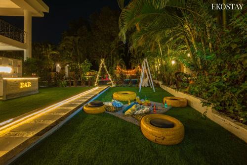 a backyard with a swimming pool with several large tires on the grass at Ekostay Luxe - CASA SIA - Ideal for Big Groups- Poker Table in Lonavala