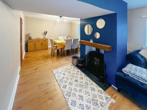 a living room with a blue wall and a dining room at Mcauley Cottage in Burgh le Marsh
