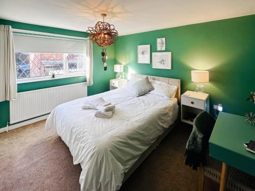 a bedroom with a bed with a green wall at Mcauley Cottage in Burgh le Marsh