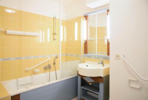 une salle de bain avec un lavabo et une baignoire et un lavabo dans l'établissement Résidence Port Bourgenay - maeva Home - Studio 5 Personnes Sélection MAE-2339, à Talmont-Saint-Hilaire