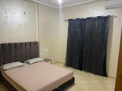 a bedroom with a bed and a black curtain at E Nice one bedroom apartement wifi in Fez