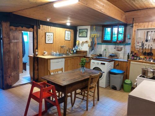 a kitchen with a wooden table and a table and chairs at Chalet La Gayolle - Chalets pour 12 Personnes 96 in Saint-Gervais-les-Bains