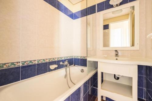 une salle de bain avec une baignoire et un lavabo dans l'établissement Résidence le Village de Cap Esterel - maeva Home - Studio 4 personnes - Confort MAE-2362, à Saint-Raphaël