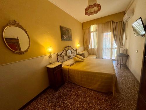 una camera con un grande letto e uno specchio di Hotel Fontana a Venezia