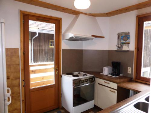 Il comprend une petite cuisine avec une cuisinière et une fenêtre. dans l'établissement Chalet Pylone - Chalet Pylone MAE-5198, à Saint-Gervais-les-Bains
