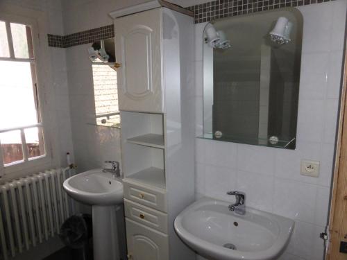 une salle de bain blanche avec un lavabo et un miroir dans l'établissement Chalet Pylone - Chalet Pylone MAE-5198, à Saint-Gervais-les-Bains