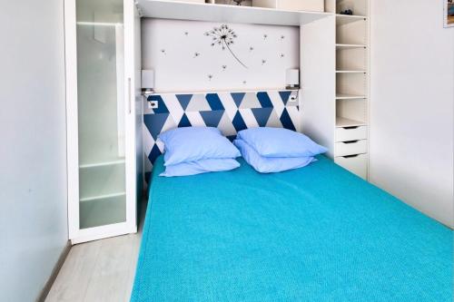 a bedroom with a bed with two blue pillows at Résidence Les Balcons de Collioure - maeva Home - Appartement 2 Pièces 4 Personnes Prestige - Vue mer MAE-3596 in Collioure