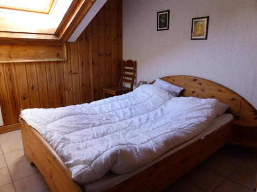 une chambre avec un lit en bois avec des draps blancs dans l'établissement Résidence Les Jardins Alpins - Jardins Alpins B29 MAE-5209, à Saint-Gervais-les-Bains