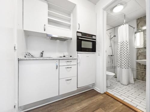 a white kitchen with a sink and a toilet at Nordbo in Centrum in Nuuk