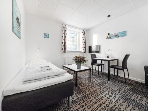 Schlafzimmer mit einem Bett, einem Tisch und Stühlen in der Unterkunft Nordbo in Centrum in Nuuk