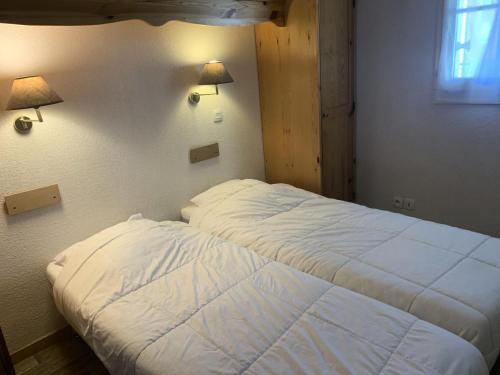 two beds in a room with two lamps on the wall at Résidence Le Grand Panorama - 2 Pièces pour 6 Personnes 13 in Saint-Gervais-les-Bains