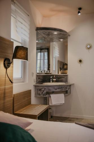 - une chambre avec un lavabo et un miroir dans l'établissement La Verrerie, à Gaillac