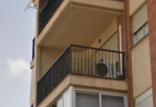 a building with a balcony with a cat sitting on it at Piso completo en Calle La Huerta in San Vicente del Raspeig