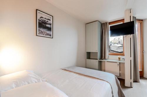 une chambre blanche avec un lit et une fenêtre dans l'établissement Résidence Les Fontaines Blanches - maeva Home - 2 Pièces 4 Personnes Sélection MAE-3634, à Morzine