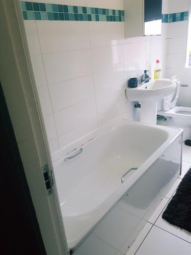 a white bathroom with a tub and a sink at Double Room Close To Headingley Stadium Leeds in Leeds