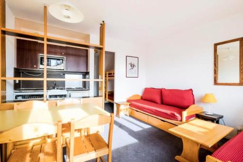 un salon avec un canapé rouge et une table dans l'établissement Résidence Les Fontaines Blanches - maeva Home - Studio 4 Personnes Budget MAE-3721, à Morzine