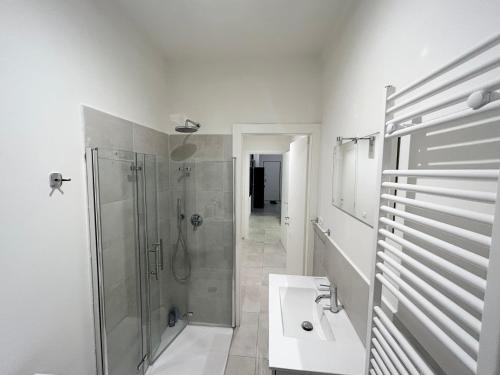a white bathroom with a shower and a sink at Casa MEC Imperia in Imperia