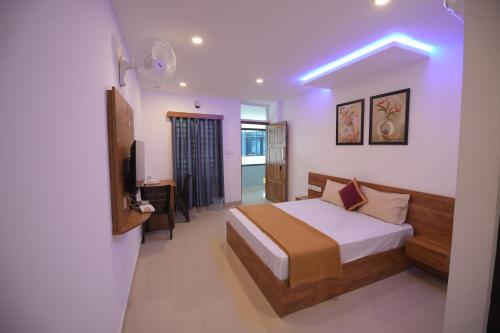 1 dormitorio con 1 cama y TV en una habitación en Queen-C Inn, en Mānantoddy