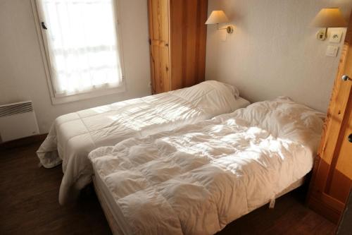une chambre avec deux lits avec des draps blancs et une fenêtre dans l'établissement Résidence Le Grand Panorama - Grand Panorama 105 MAE-5237, à Saint-Gervais-les-Bains