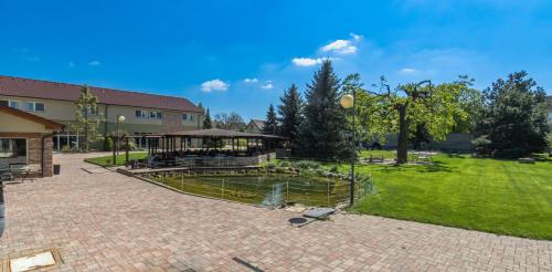 a backyard with a pond and a pavilion at Hotel Dvůr in Krnsko