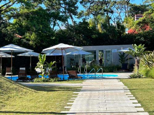 a patio with umbrellas and chairs and a pool at Apartamento a estrenar en MANSA INN!! in Punta del Este
