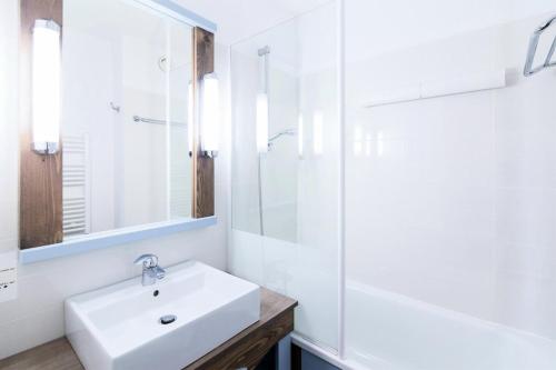 une salle de bain blanche avec un lavabo et une douche dans l'établissement Résidence Port Bourgenay - maeva Home - 2 Pièces 4 Personnes Sélection MAE-5309, à Talmont-Saint-Hilaire
