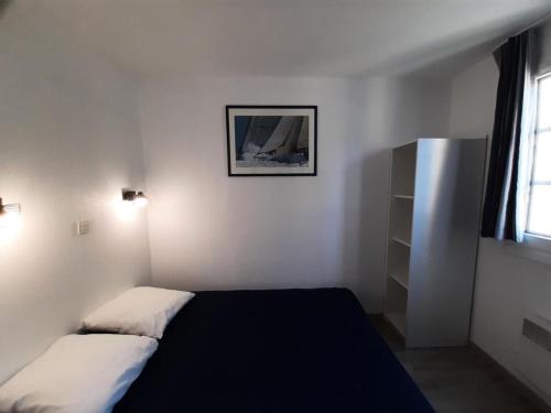 une chambre avec deux lits et un tableau au mur dans l'établissement Résidence Port du Crouesty - maeva Home - Appartement 2 pièces 4 personnes - Confort MAE-5428, à Arzon